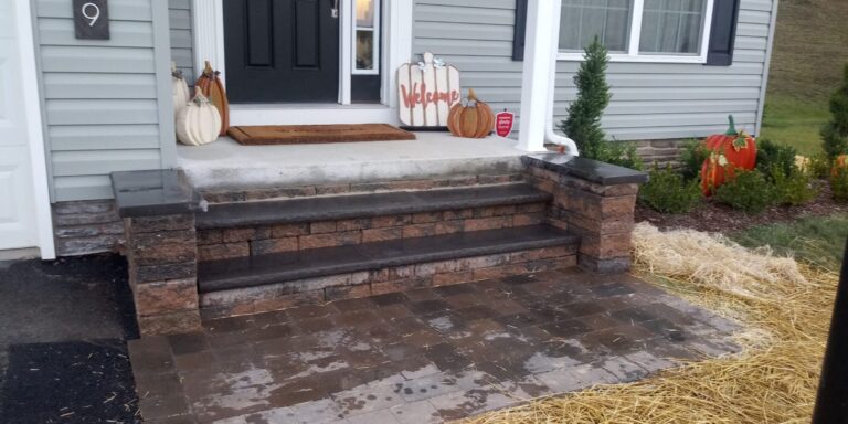 New block steps and pillars with dark caps leading to a front porch decorated for fall in York PA