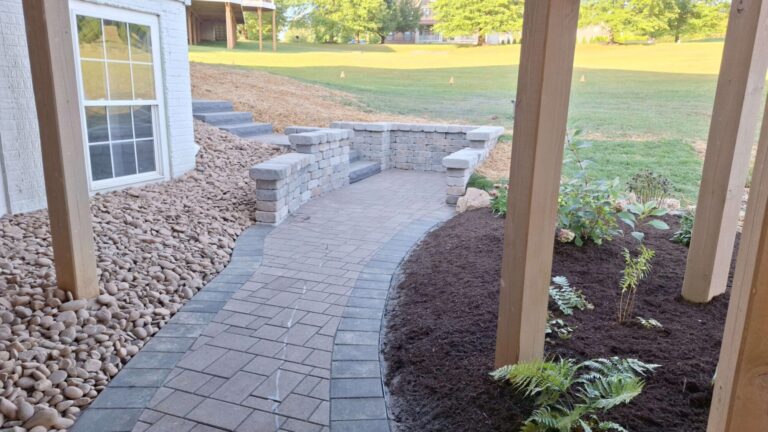 Bordered paver walkway leading to a small patio nook wrapped in stacked stone seat walls in York PA.